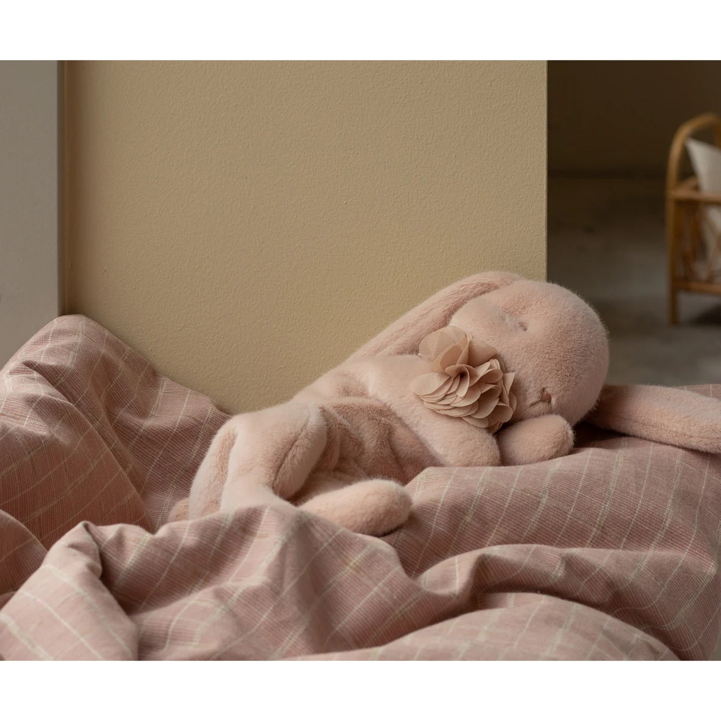 Coelhinho a dormir Maileg pequeno em rosa pastel, com gola de malha e flor de chiffon, visto de frente