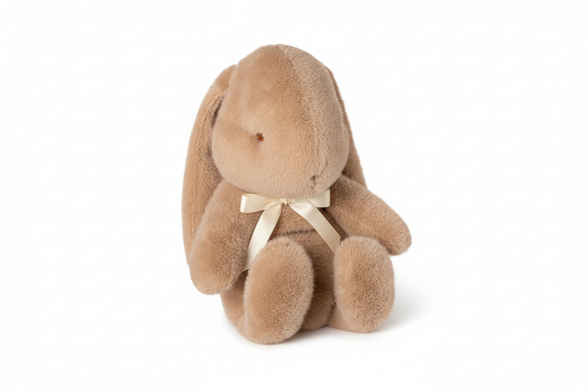 Coelhinho de peluche Maileg médio em pêssego creme, com laço ao pescoço, visto de frente