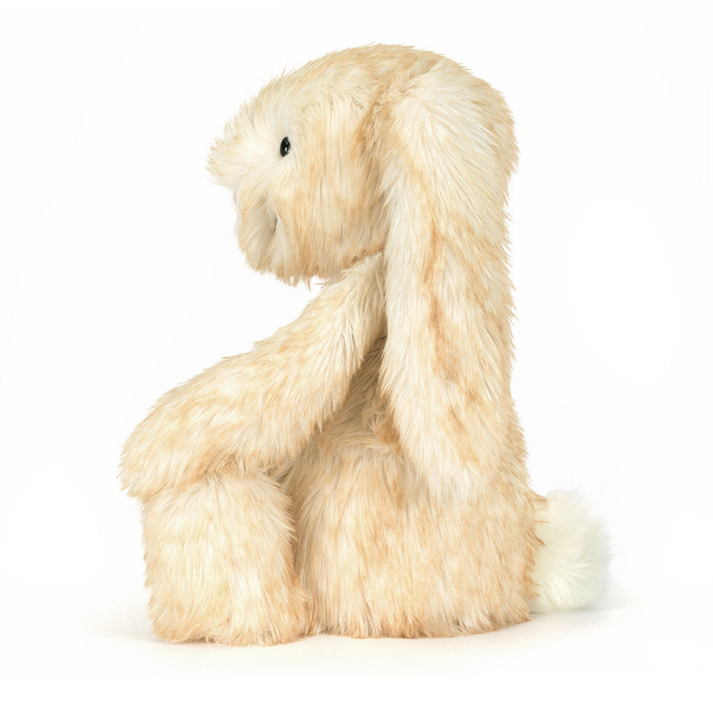 Vista lateral do Peluche Jellycat Springlowe Luxe Bunny sentado com pelo rosa