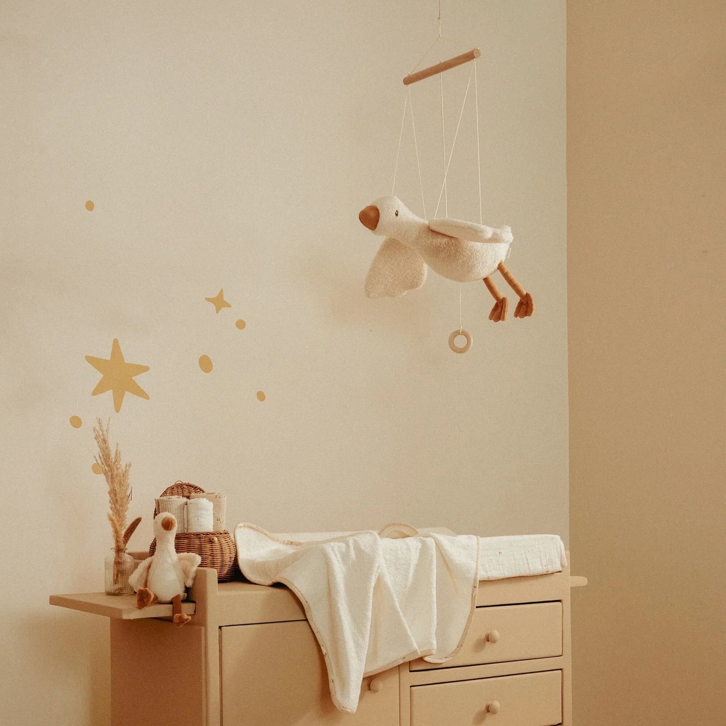 Quarto infantil decorado com o Ganso Flutuante Little Goose pendurado sobre o berço.