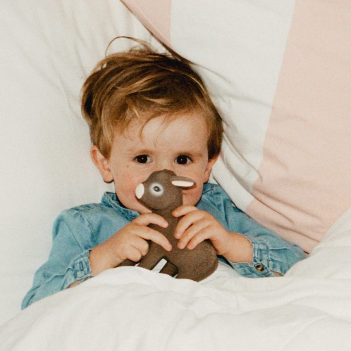 Criança na cama com o mordedor Hector o Burro | oli-carol-mordedor-burro-hector-lollakids
