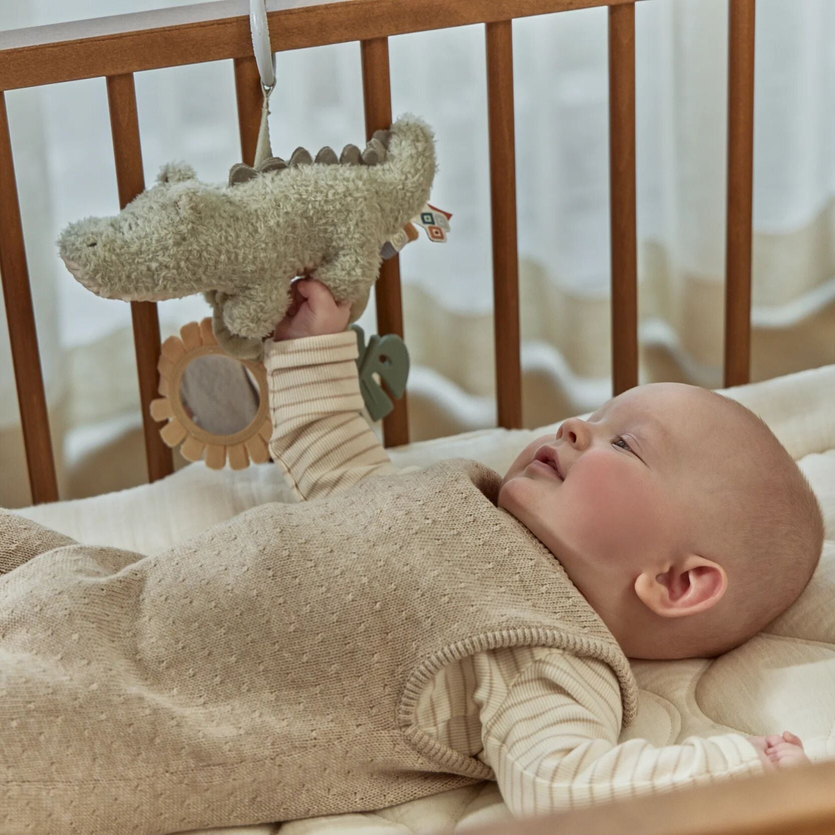 Bebé a brincar com pendente de atividades crocodilo Little Dutch