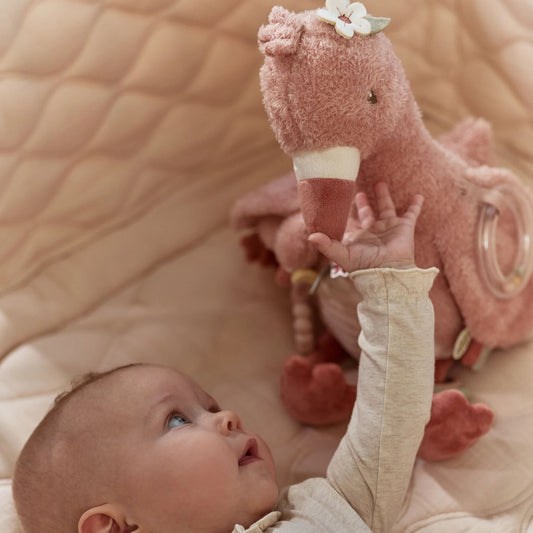 Bebé a brincar com peluche de atividades flamingo