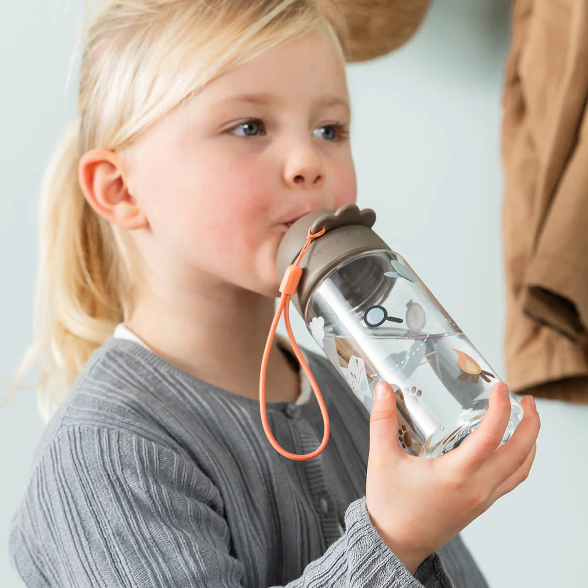 Garrafa com palhinha Done by Deer Tiny Trails Sand 350ml criança a usar | done-by-deer-garrafa-palhinha-tinytrails-sand-lollakids