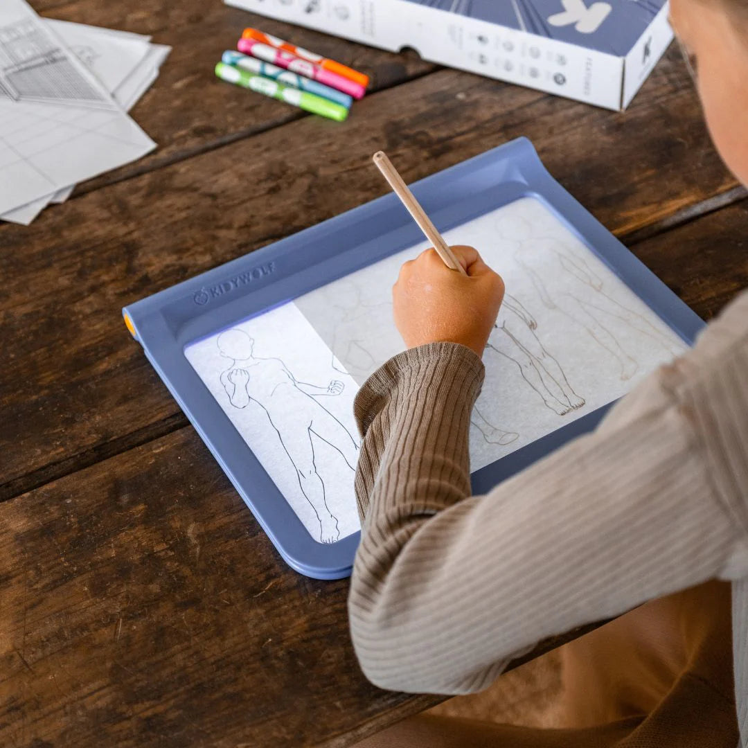 Criança a desenhar personagens de manga na mesa de desenho K-DRAW PRO com ecrã luminoso e decalques combináveis.
