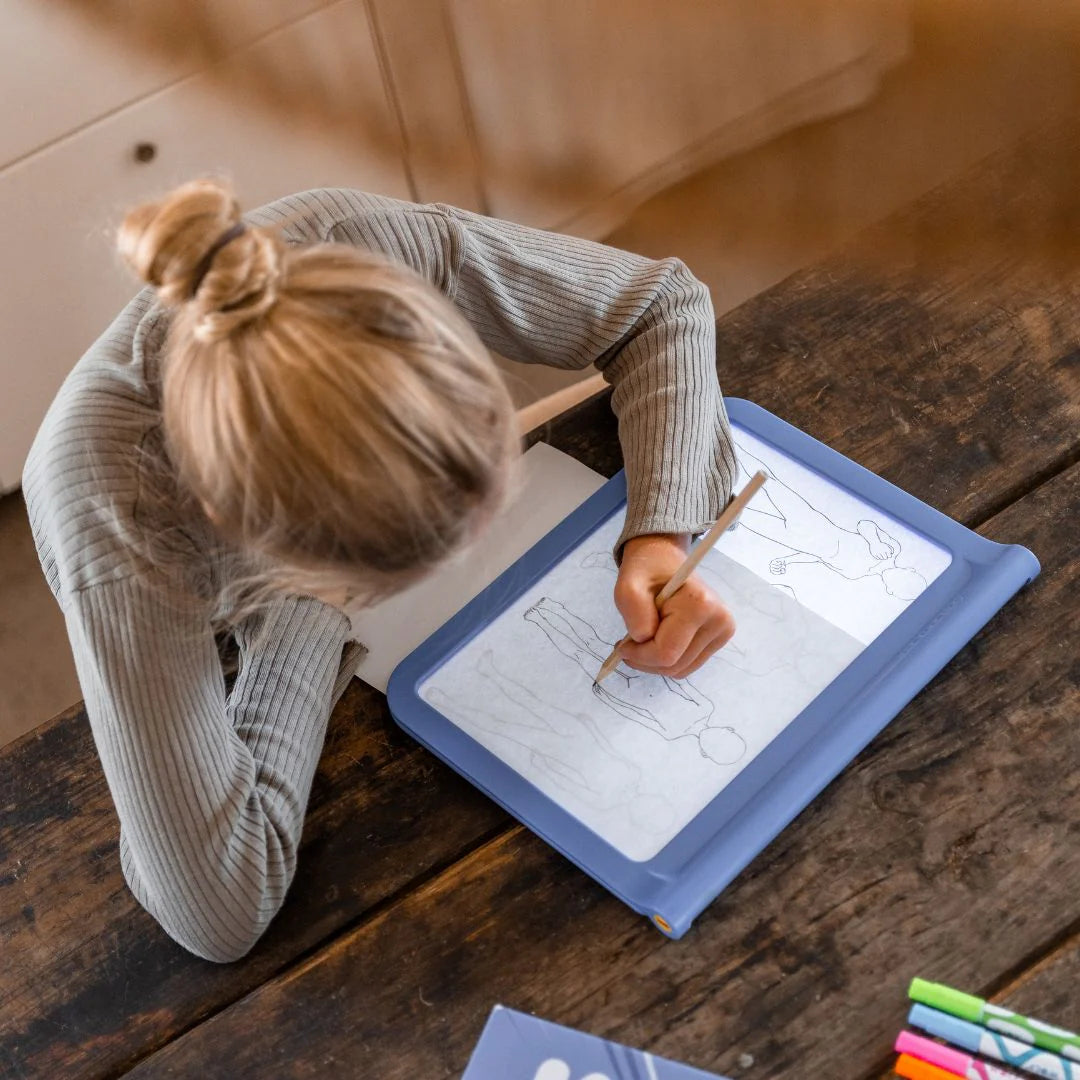 Criança a desenhar personagens de manga na mesa de desenho K-DRAW PRO com ecrã luminoso e decalques combináveis.