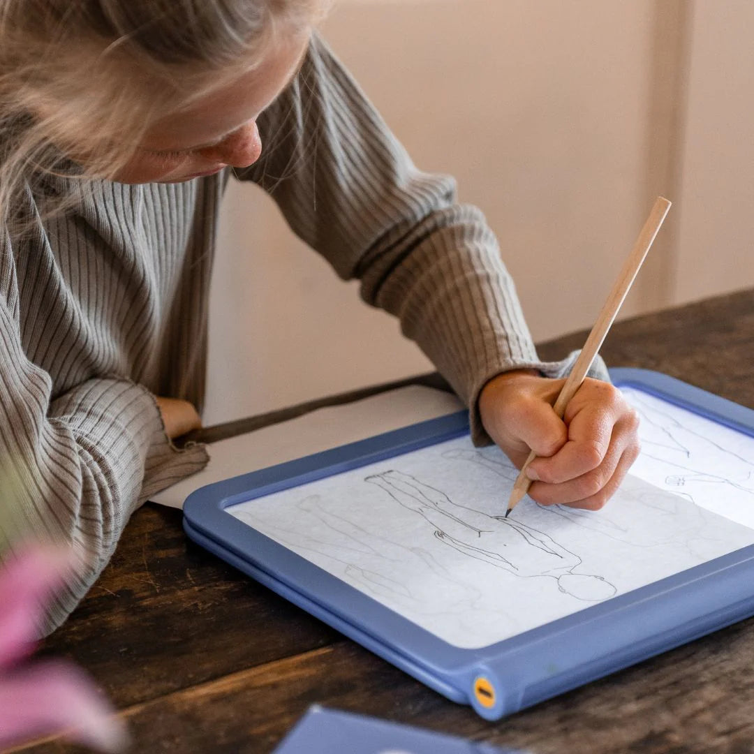 Criança a desenhar personagens de manga na mesa de desenho K-DRAW PRO com ecrã luminoso e decalques combináveis.