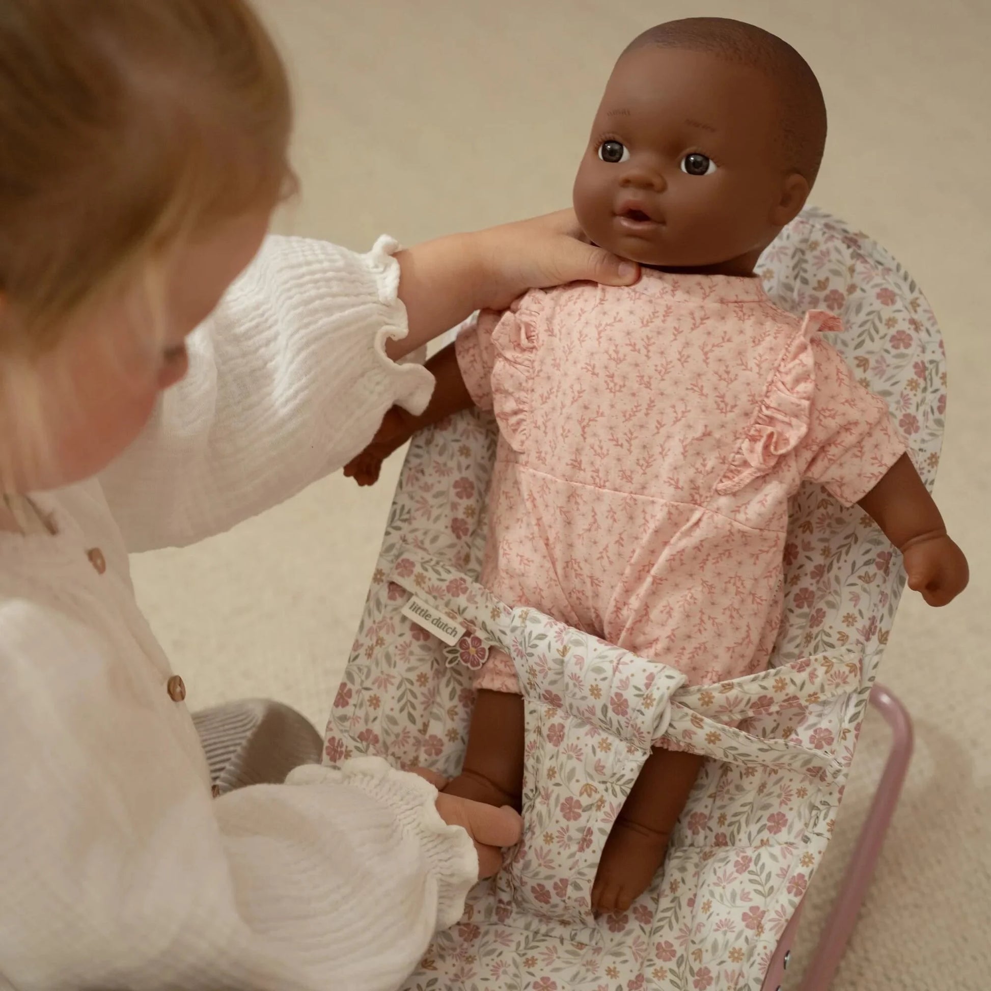 Menina que introduz a boneca na Espreguiçadeira para Bonecas Soft Flowers