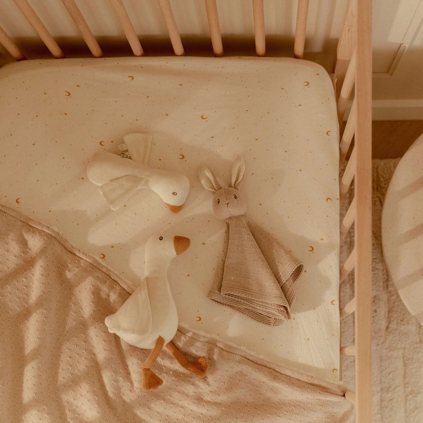 3 acessórios do Conjunto de Nascimento Newborn Naturals Bege expostos em berço