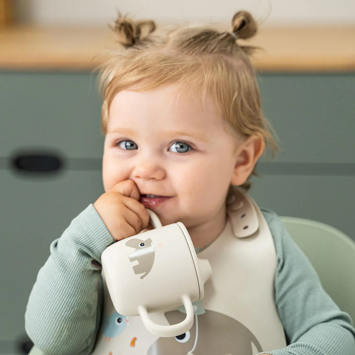 Criança a vestir o Babete silicone Done by Deer Celebration Sand com bolso