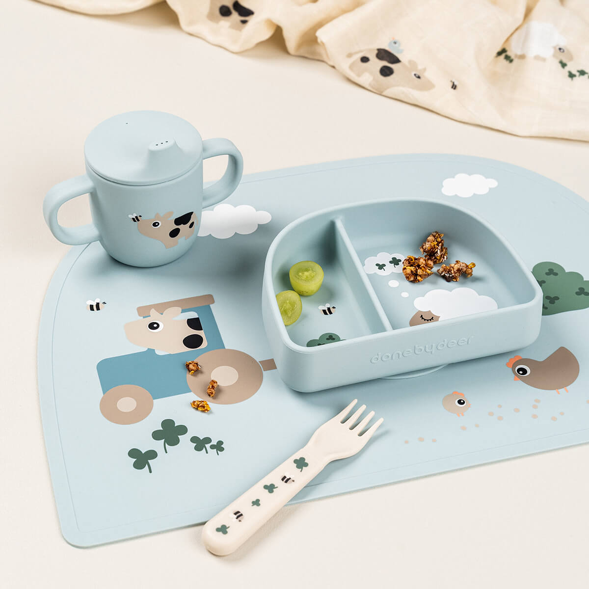 Bebé a usar o copo de silicone Tiny Farm Blue Done by Deer | done-by-deer-copo-tiny-farm-uso-lollakids