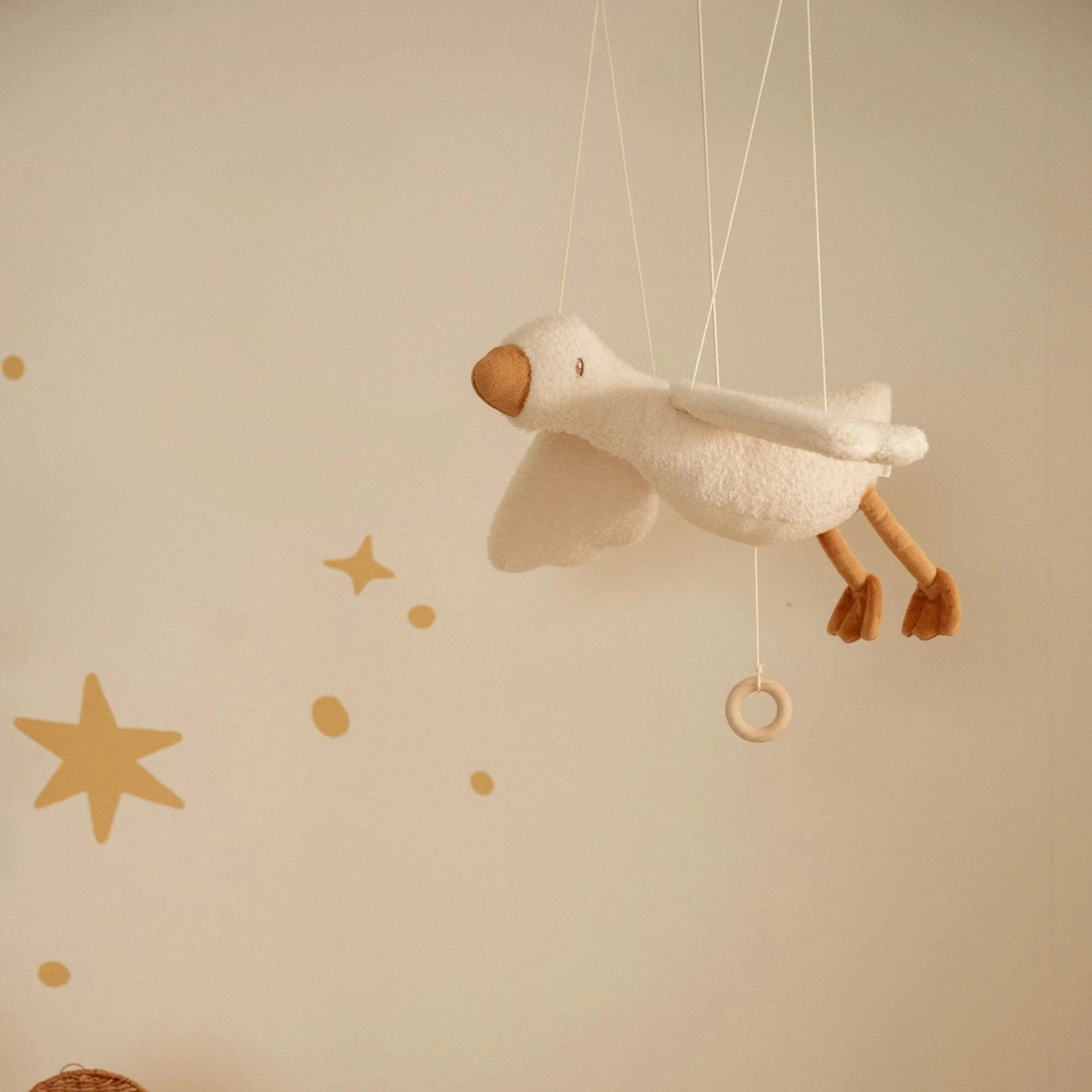 Quarto infantil decorado com o Ganso Flutuante Little Goose pendurado sobre o berço.