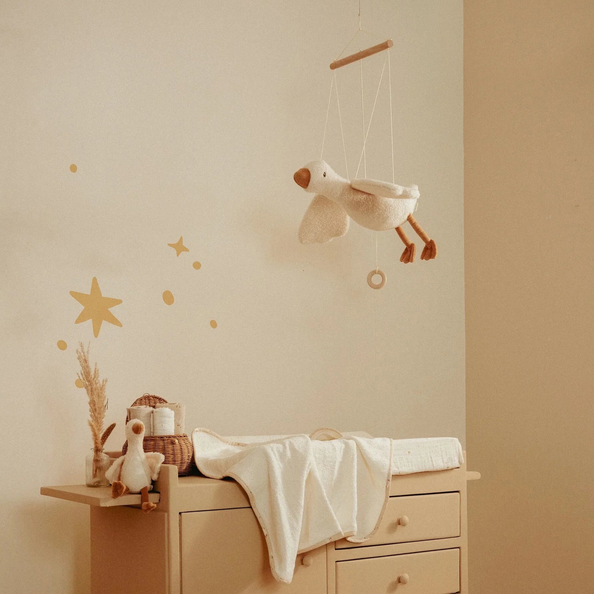 Quarto infantil decorado com o Ganso Flutuante Little Goose pendurado sobre o berço.