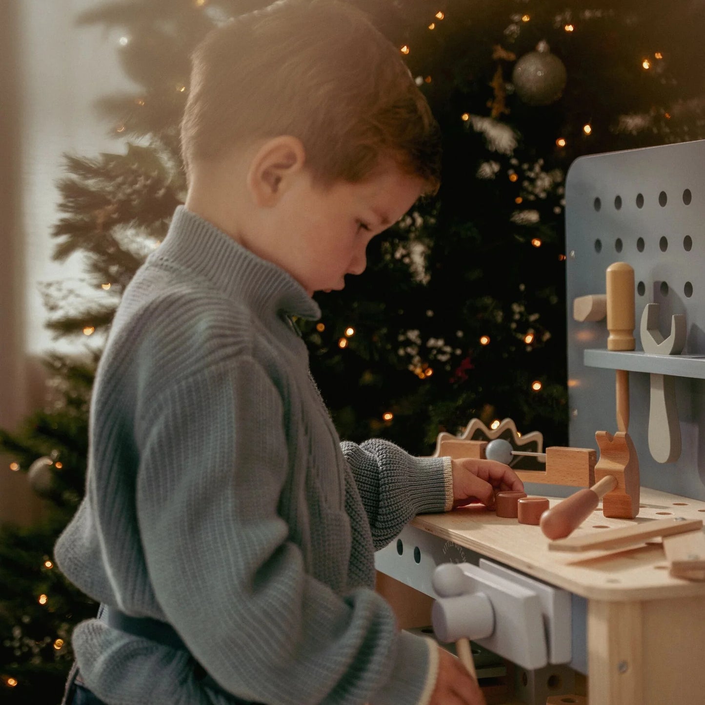 Criança a brincar na bancada de ferramentas de madeira azul little dutch essentials