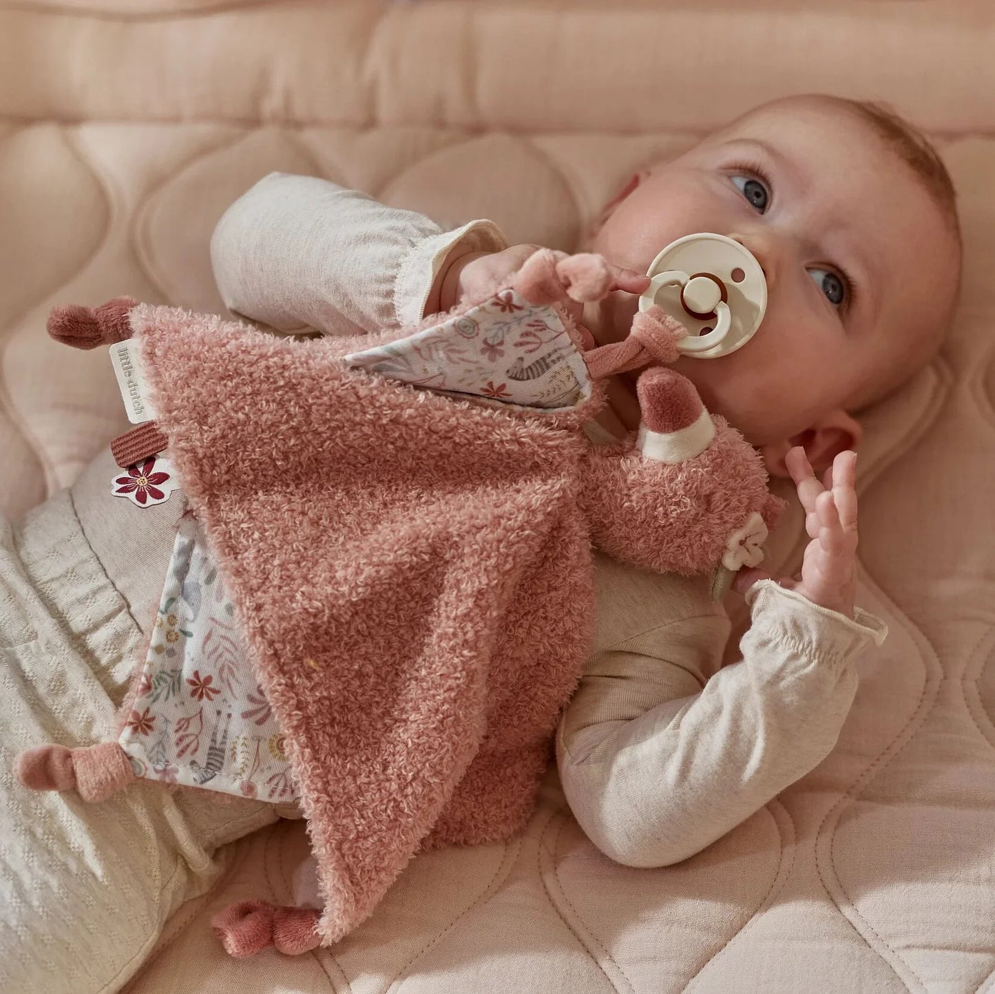 Bebé com doudou flamingo rosa e chupeta