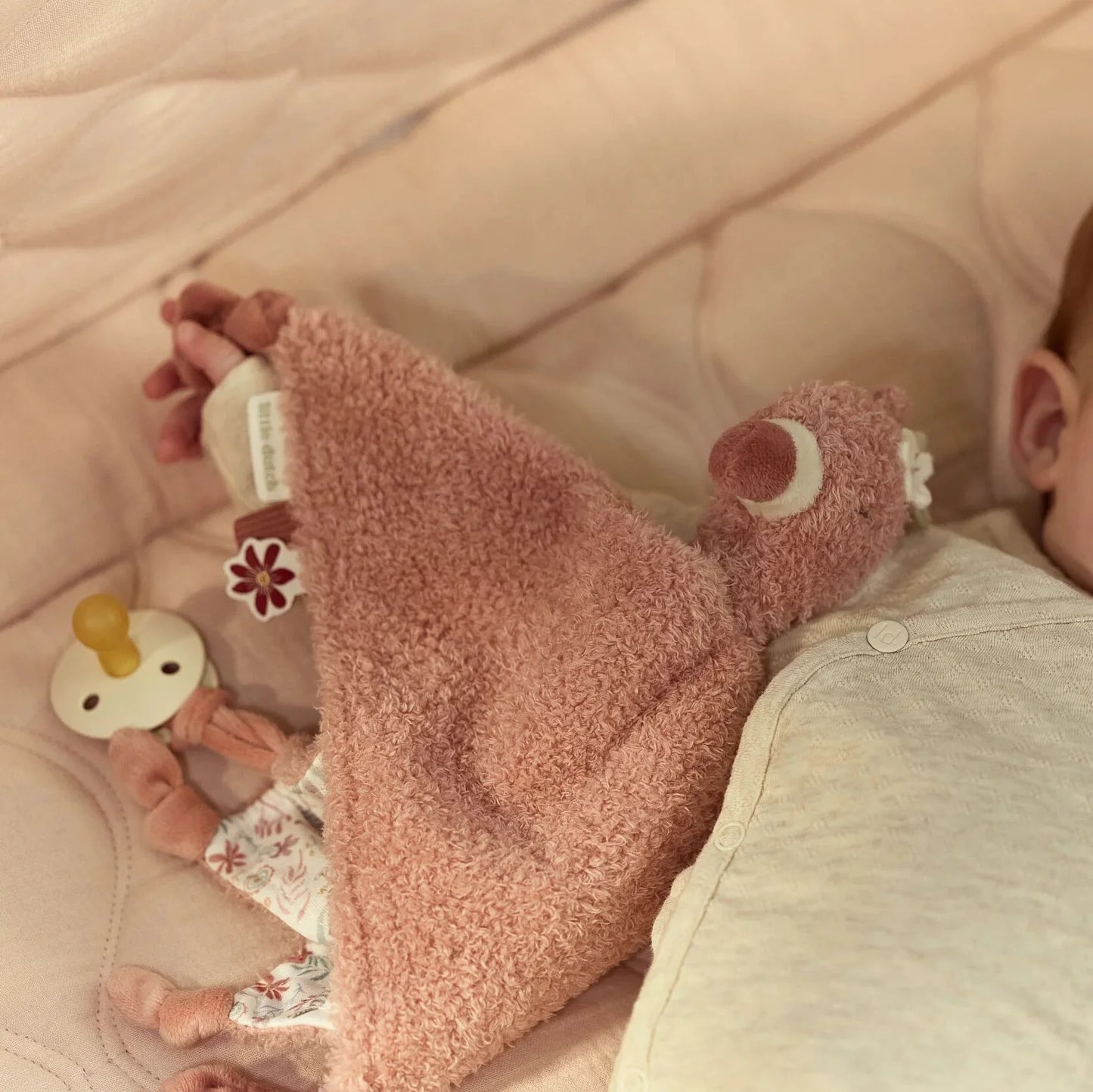 Bebé deitado com doudou flamingo Little Dutch