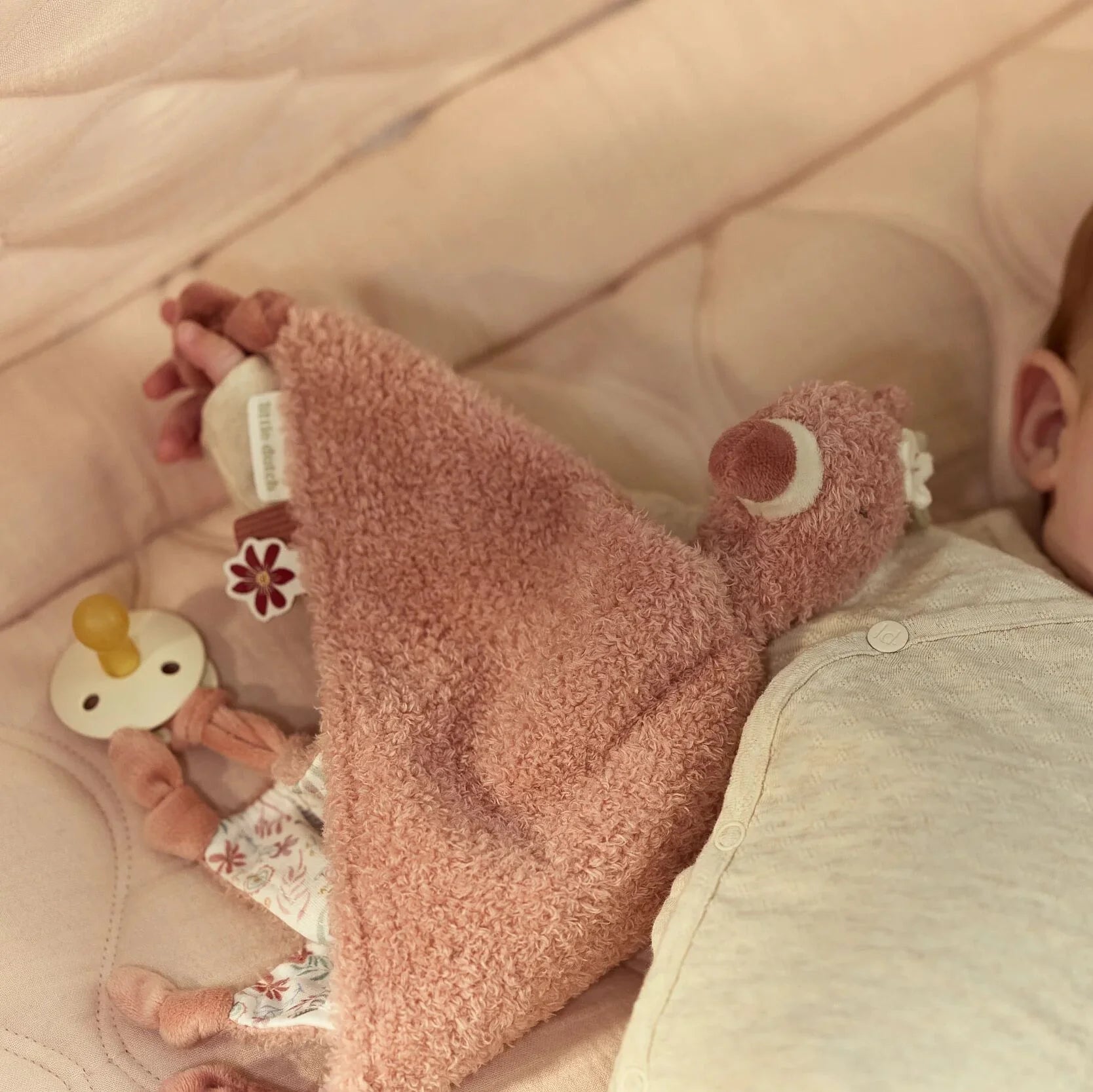 Bebé deitado com doudou flamingo Little Dutch
