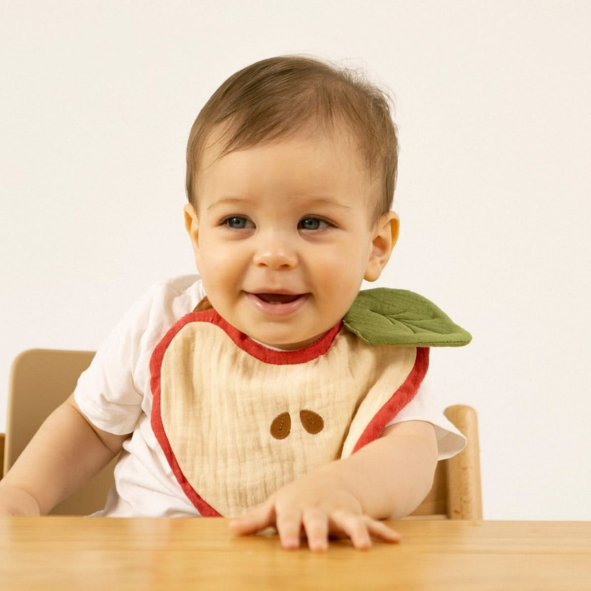 Bebé sorridente com o babete Pepa a Maçã da Oli & Carol | oli-carol-babete-maca-lollakids